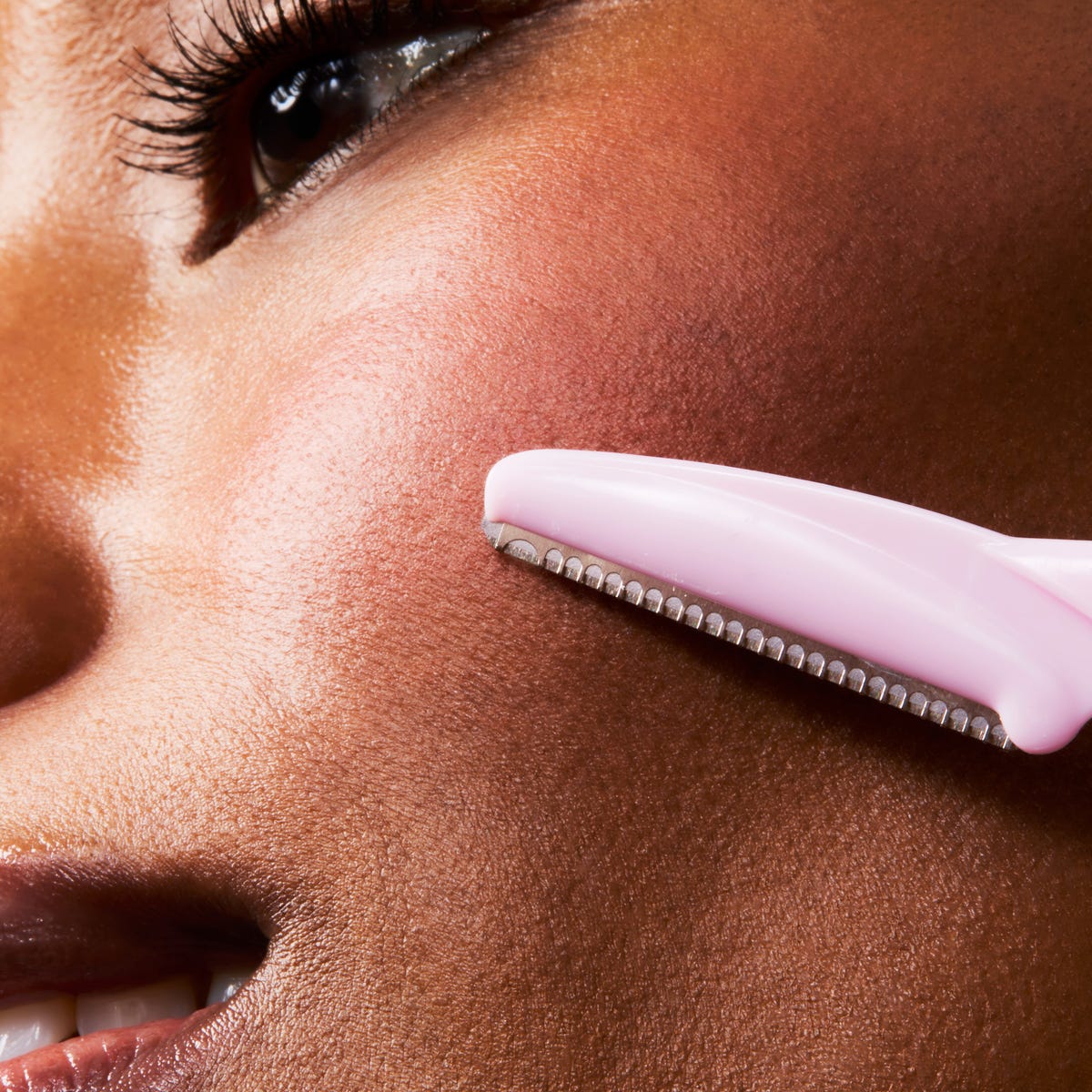 Woman dermaplaning face at home skincare editorial