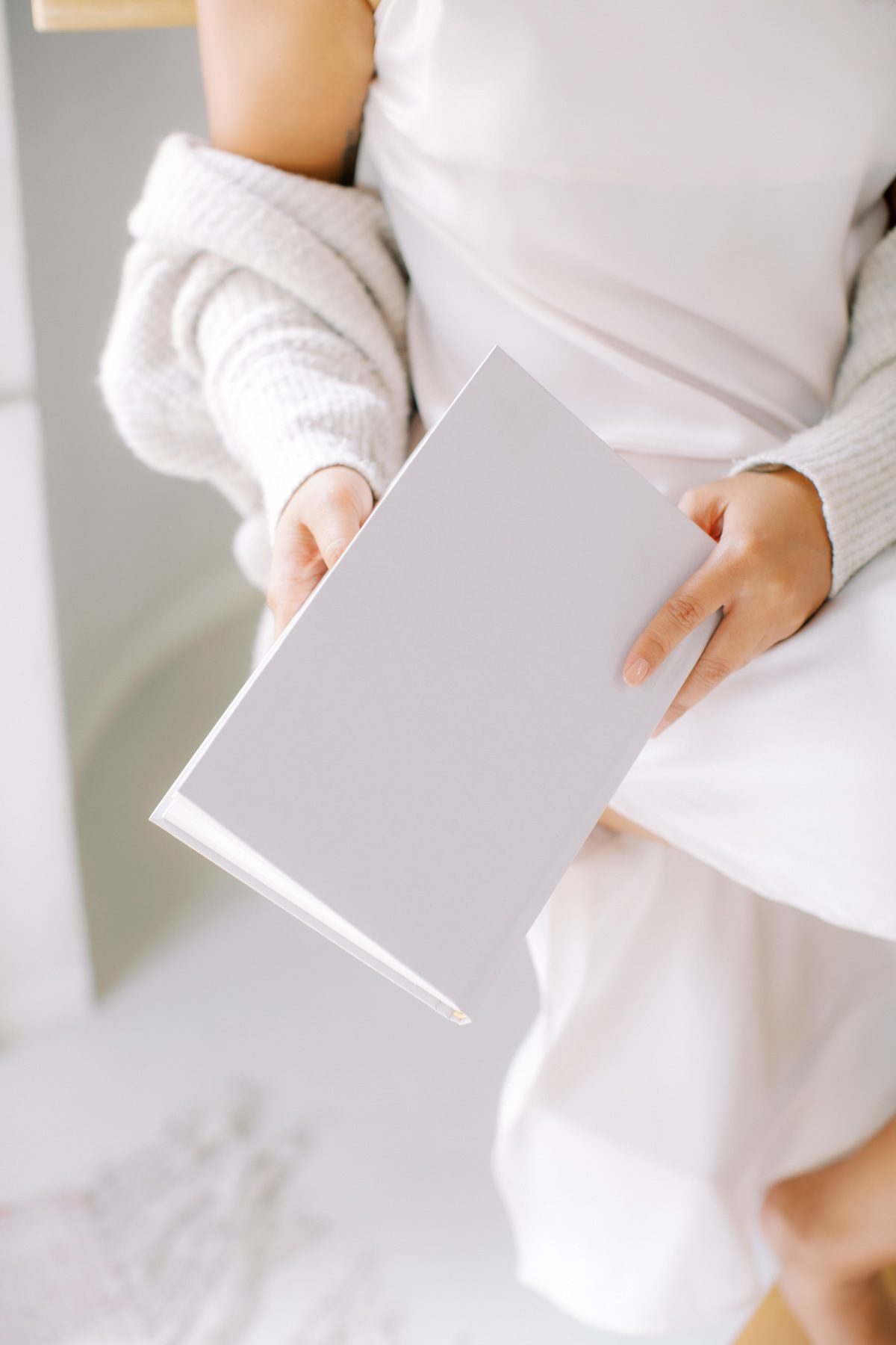 Woman in cardigan holding a journal for beginners morning routine