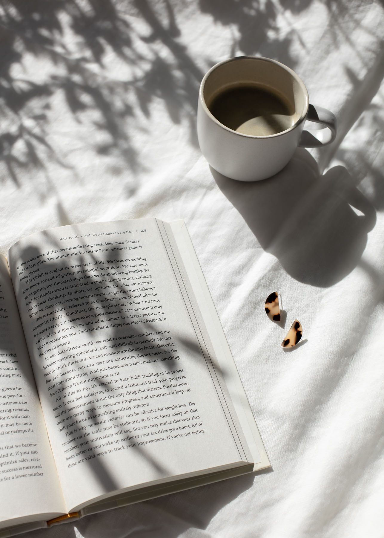 Open book and coffee on white linen with morning light for journaling beginners