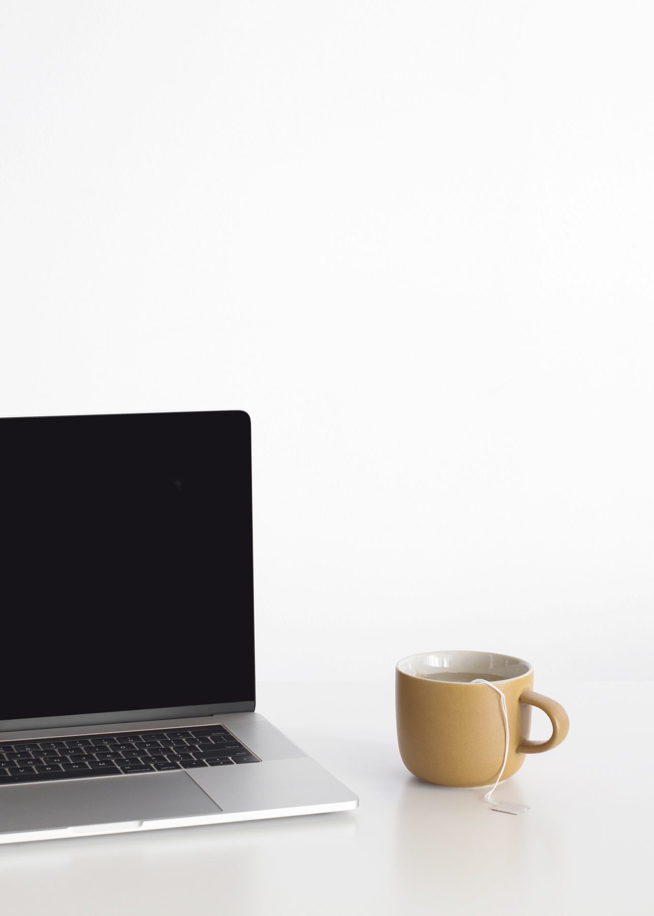 minimal desk setup with laptop and tea