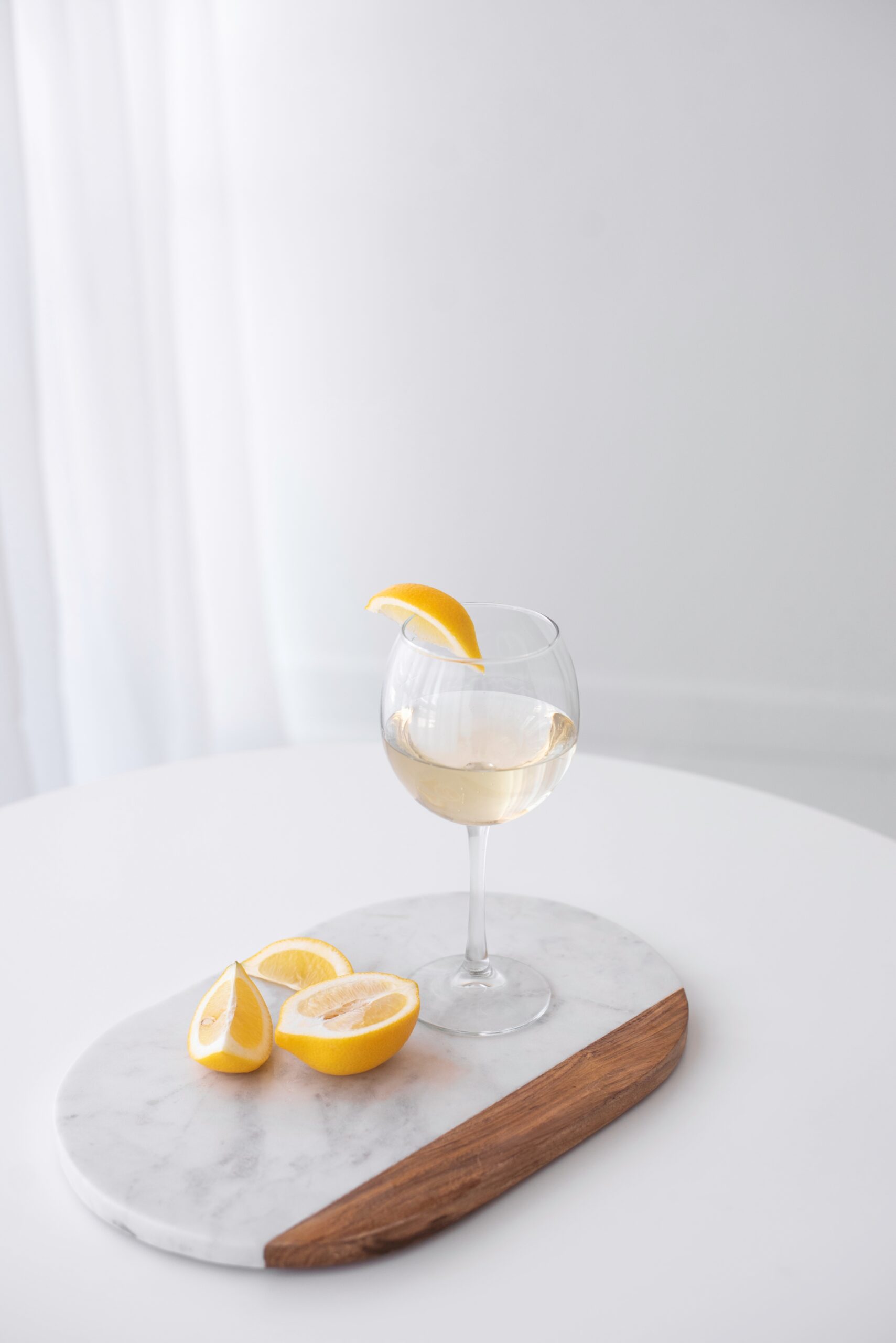 lemon slices and wine glass on marble board summer yellow aesthetic
