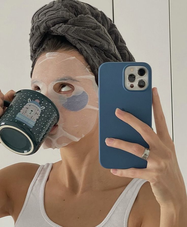 mirror selfie with sheet mask and coffee mug