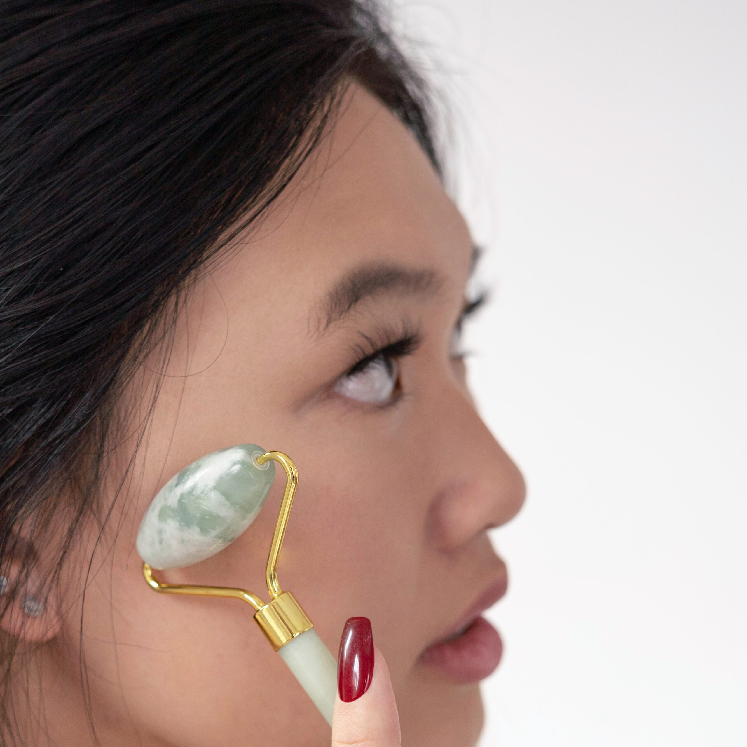 woman using jade roller on face for skincare routine