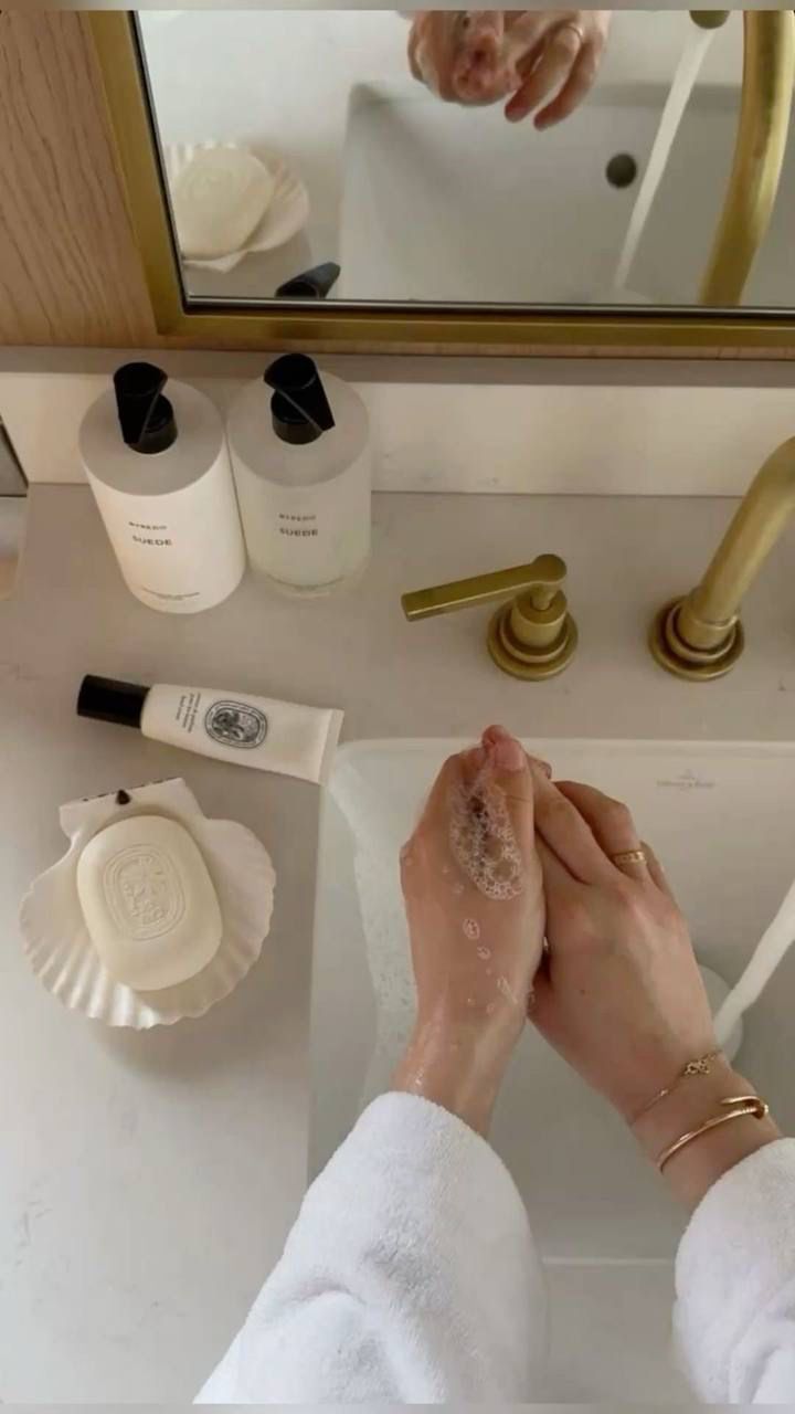 bathroom counter skincare routine with hands applying cream