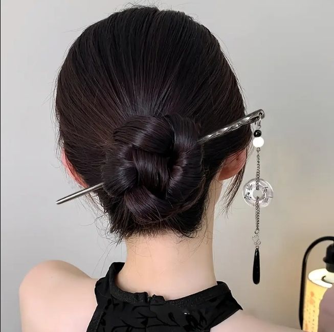low twisted bun held with a single metal hair pin