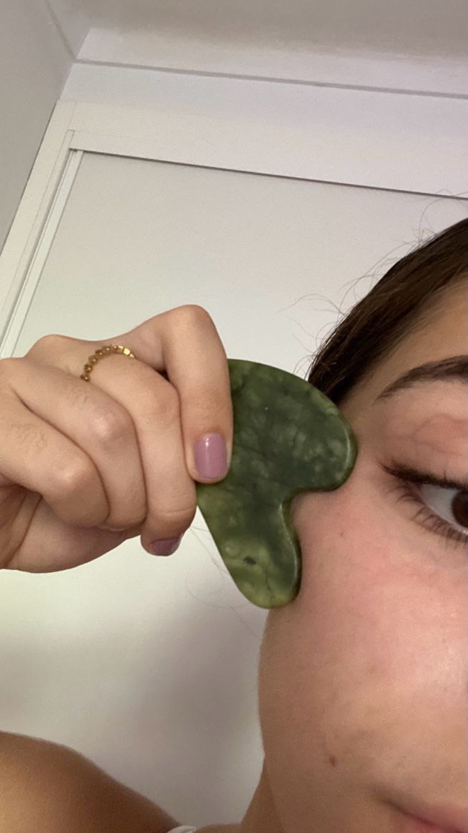 using a jade gua sha along the cheekbone