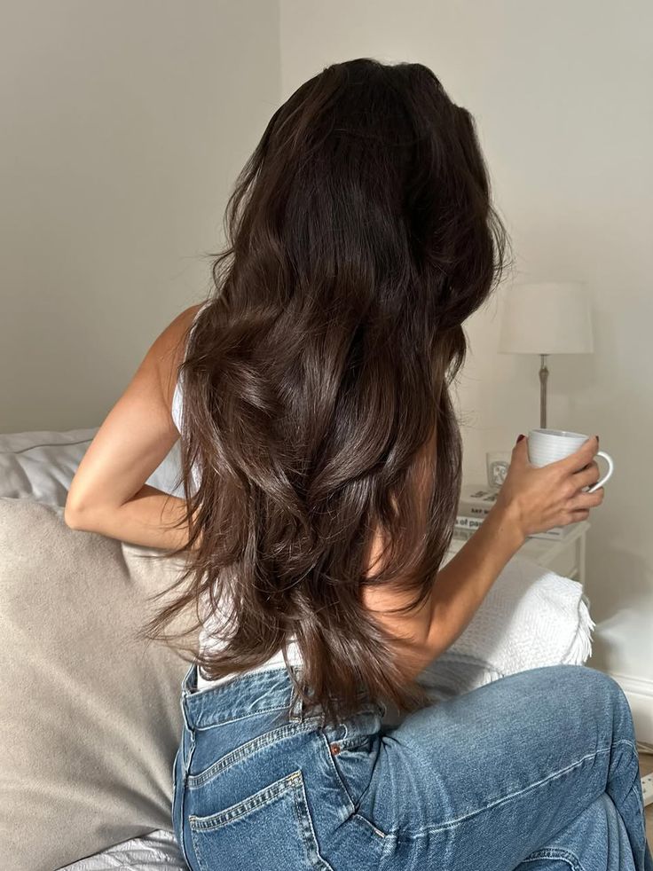 long dark wavy hair from behind with coffee