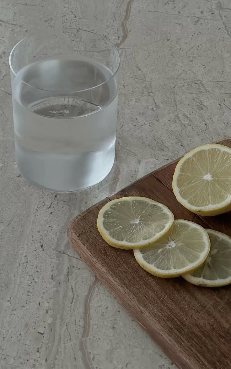 lemon slices and glass of water on marble counter