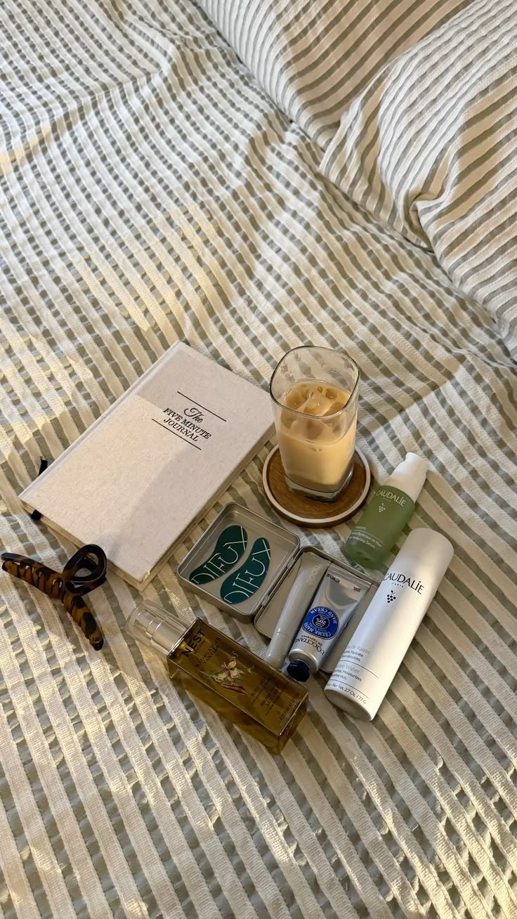 morning skincare products and journal on bed