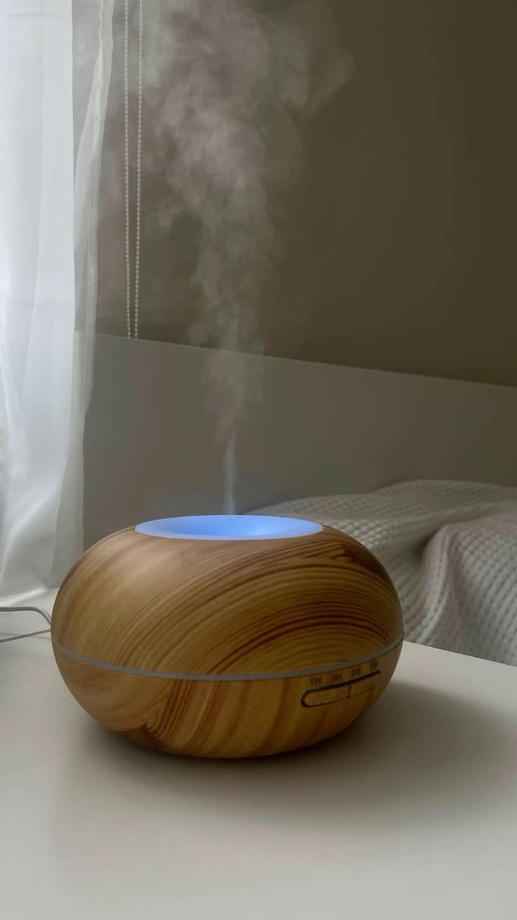 wood grain essential oil diffuser releasing steam on a bedside table
